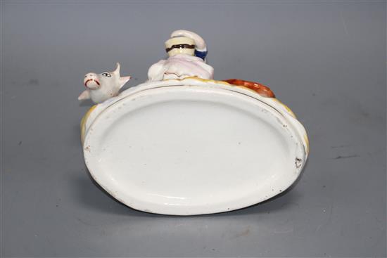 A Staffordshire pottery group of a milkmaid and cow, L. 21cm